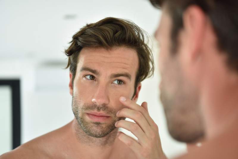 man applying skin care