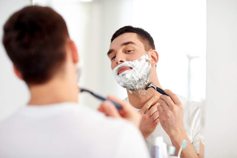 man shaving in mirror
