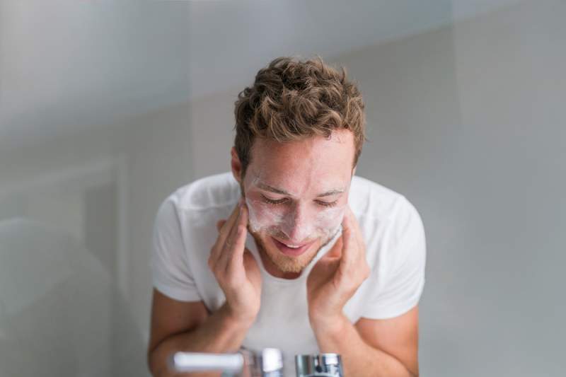man washing face
